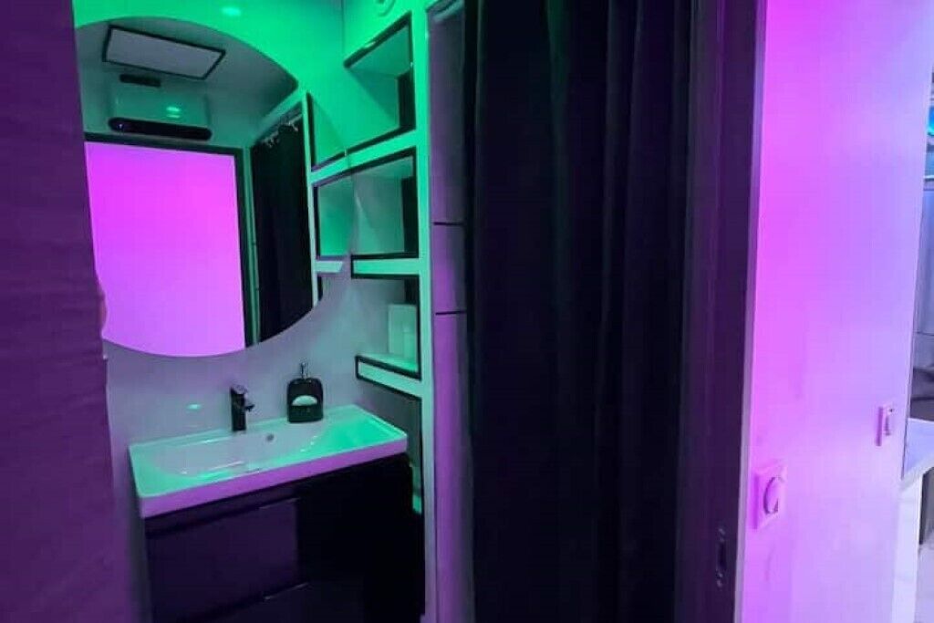 Un baño de diseño moderno, con un espejo grande, un lavabo y un armario.