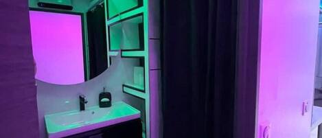 Un baño de diseño moderno, con un espejo grande, un lavabo y un armario.