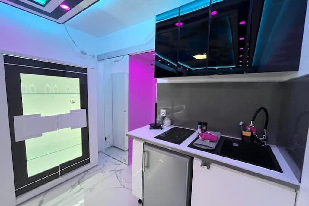 A modern kitchen with a built-in refrigerator, a sink, and a countertop.