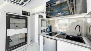 Eine moderne Küche mit Einbau-Mikrowelle, Kaffeemaschine und Spüle.