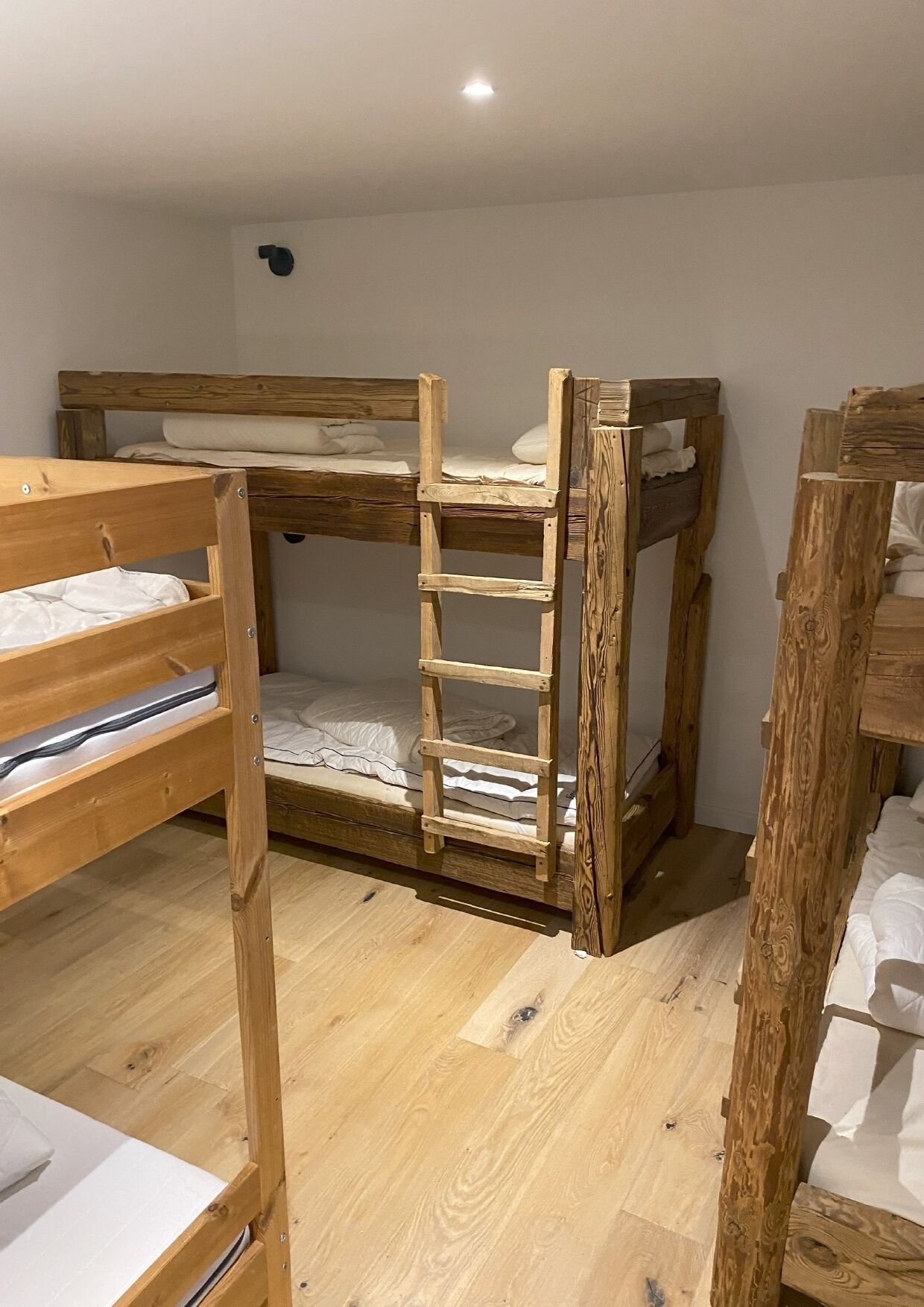 A bunk bed room with wooden frames and a ladder.