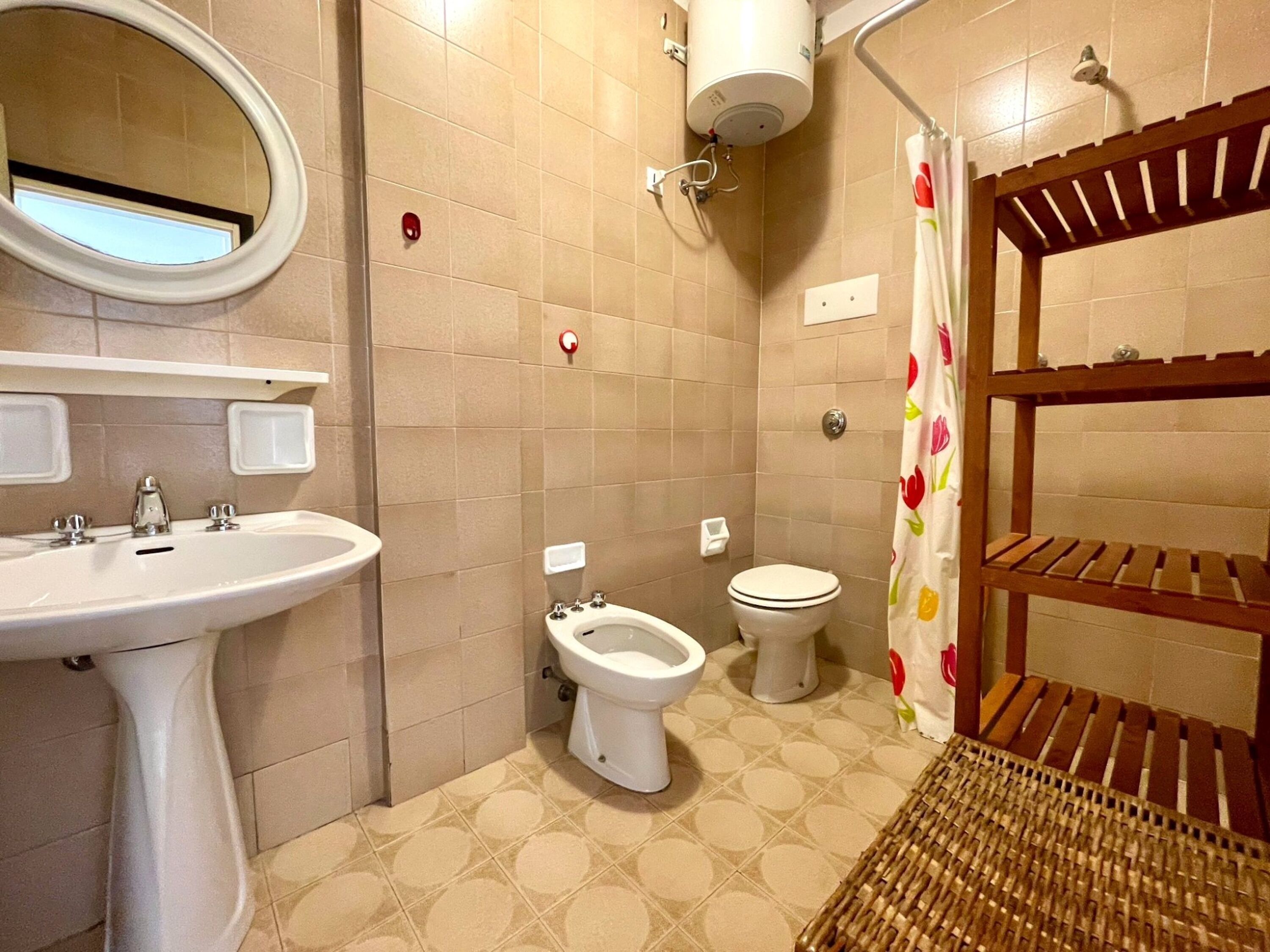 A bathroom with a sink, toilet, and shower area.