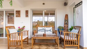 A wooden dining table with chairs, a woven rug, and artwork on the walls. - Beach Front Luxury Designer Two Bedroom Apartment (CT)