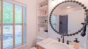 Un baño con inodoro, lavamanos y espejo.