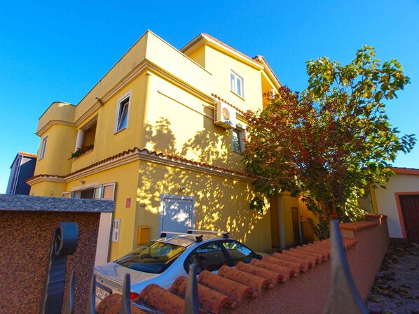 Stunning two-story building with a balcony and a tree in front.