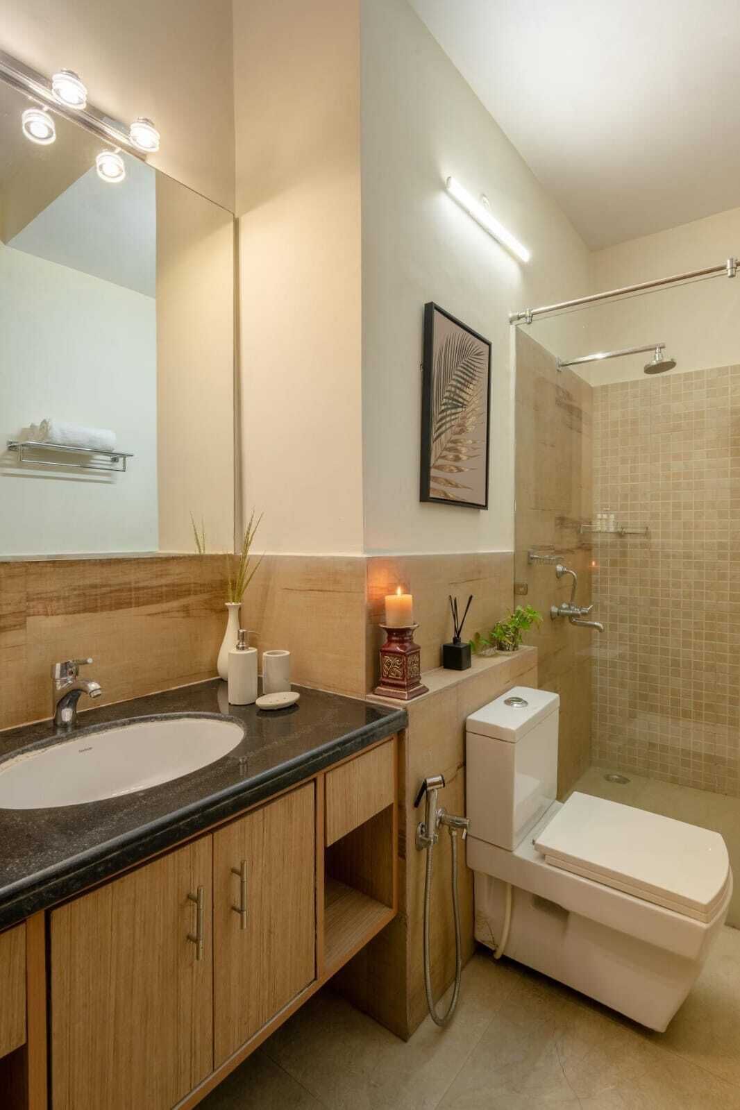 A modern bathroom with a large mirror, two sinks, a toilet, and a shower.