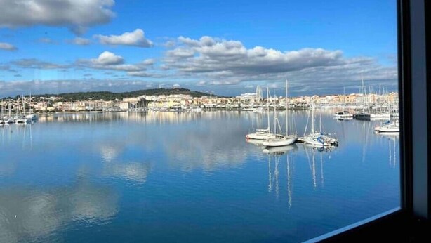 A marina with boats docked, calm water, and a distant cityscape. - Apartment 46 (Agde)