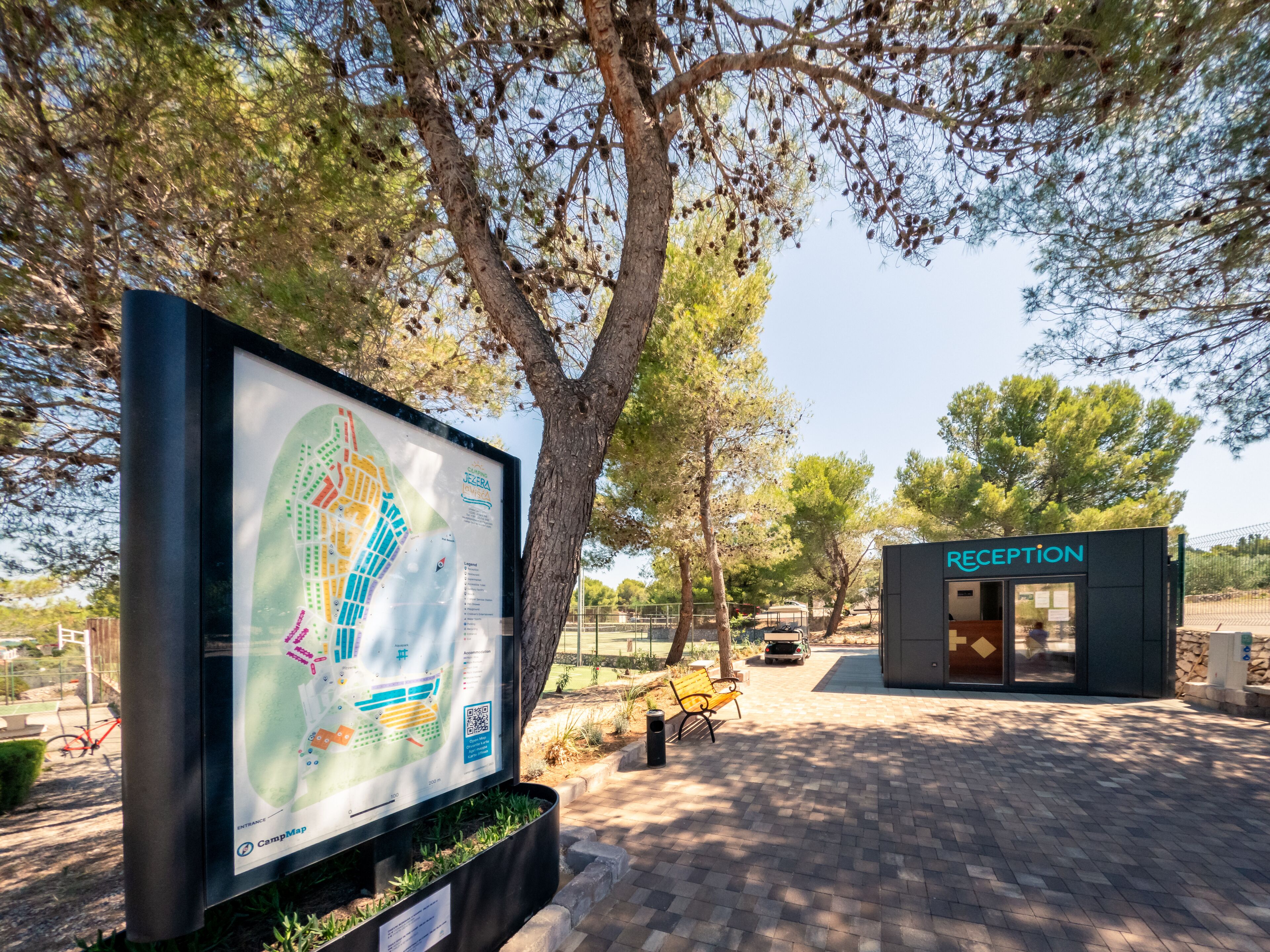 Zona de recepción con mapa y un banco.