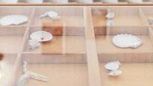 A dining table with chairs, a checkered floor, and a glass display case with decorative items. - Holiday apartment near the beach (Pješćana Uvala)