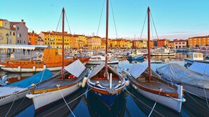 Un port de plaisance où sont amarrés plusieurs bateaux, entouré de bâtiments aux couleurs vives.