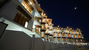 A multi-story hotel with balconies and illuminated windows at night. - Hotel Martsemik (Leh)