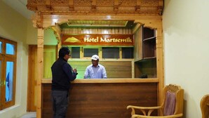 A wooden reception desk with a sign reading "Hotel Martsemil." - Hotel Martsemik (Leh)