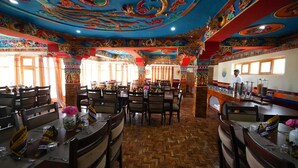 A restaurant with traditional decor, wooden tables, and chairs. - Hotel Martsemik (Leh)