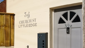 A building with a white exterior, a grey door with the number 39, and a small mailbox. - Little Edge: Bright and Modern Central Apartment (Berwick-upon-Tweed)