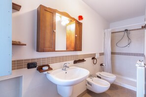Klassiek appartement | Badkamer | Een douche, een regendouche, een haardroger, een bidet