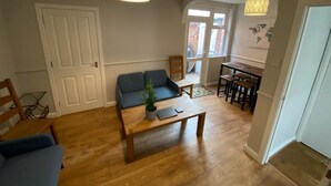 A living room with a sofa, coffee table, and a dining area with chairs.