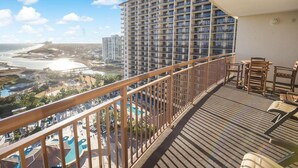 A balcony with a view of a beach and a high-rise building. - Coastal Comfort: 2BR Condo w/ Kitchen and Balcony (North Myrtle Beach)