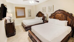 A hotel room with two wooden beds, a ceiling fan, a TV, a dresser, and artwork on the walls. - Paradise Found: Oceanfront 3-Bedroom Condo (North Myrtle Beach)