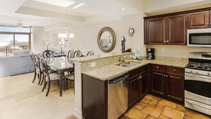 A modern kitchen with dark wood cabinets, stainless steel appliances, and a granite countertop. - Paradise Found: Oceanfront 3-Bedroom Condo (North Myrtle Beach)