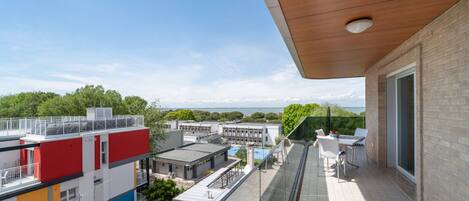 A balcony with a view of a cityscape and the sea.