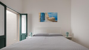 A bedroom with a bed, a window, a door, a nightstand, and a wall-mounted picture. - 3732 Le Dimore del Sole - PT by Barbarhouse (Trepuzzi)