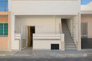 Une entrée d’immeuble avec un escalier menant à un étage supérieur.