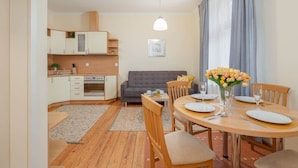 Un espace de vie compact comprenant un coin repas, une kitchenette et un canapé.