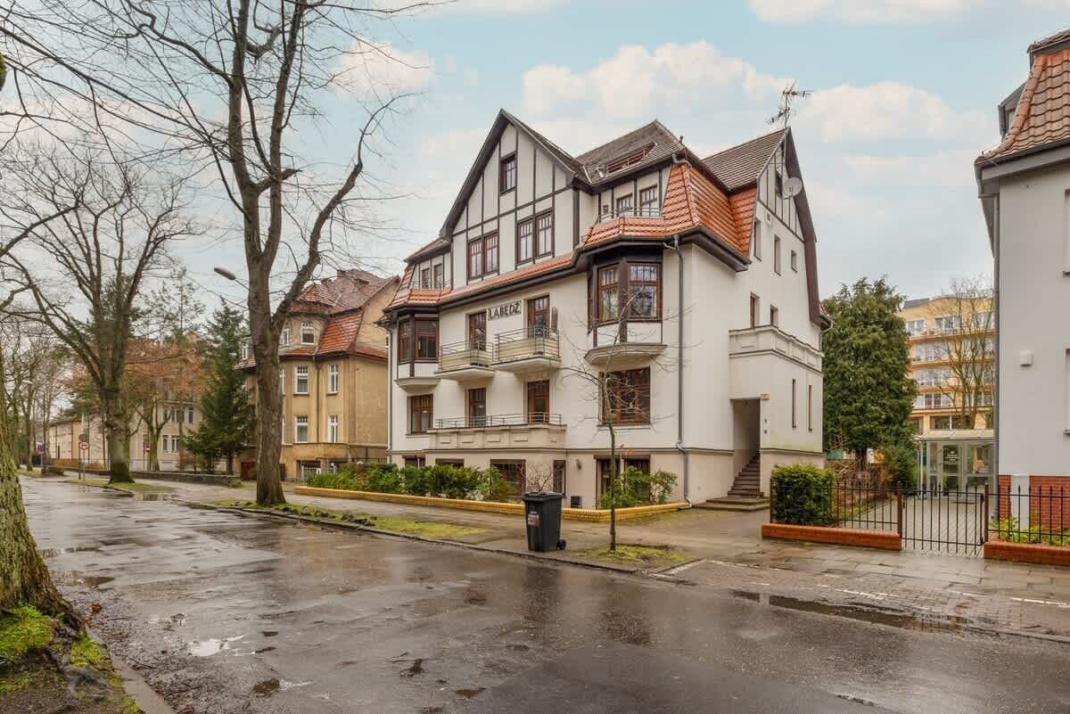 Ein Wohngebäude im traditionellen Baustil, mit einem markanten Balkon und einer sichtbaren Eingangstür.
