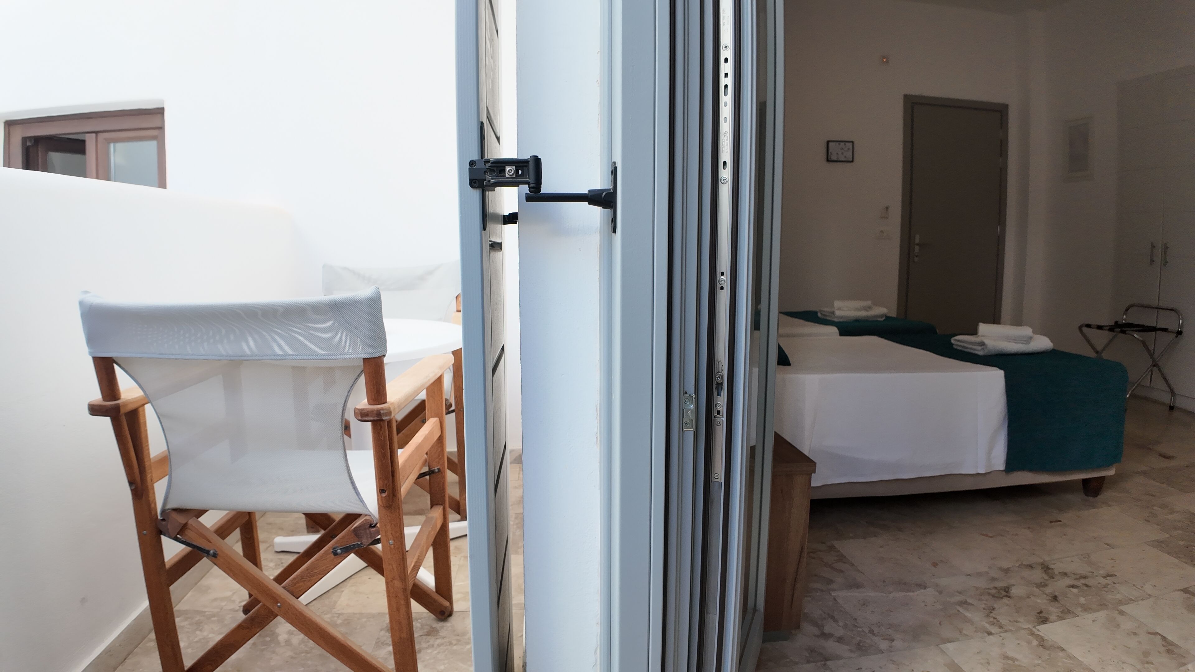 A room with a bed, a chair, and a table.