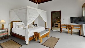 A bedroom with a four-poster bed, wooden desk, television, and a small table with a lamp. - Suarga Loka Ubud Villa (Ubud)