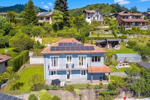 Ein Wohngebäude mit Balkon, Solaranlage und Garten.