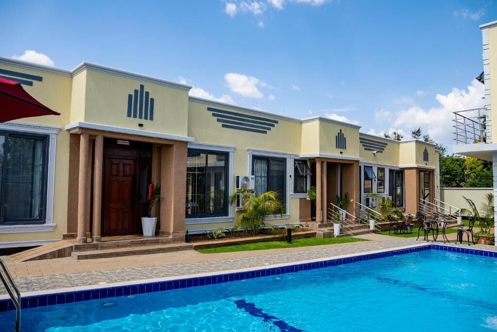 A hotel with a swimming pool, multiple rooms, and a covered outdoor area.