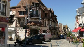 A traditional half-timbered building with a clock tower, a visible 'La Poste' sign, and a cobblestone street. - Charming 2-room apartment with balcony near the beach (Villers-sur-Mer)
