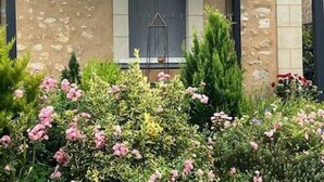 A building with a beige facade, a dark window, and a small balcony with a metal railing. - Charming Cottage with Modern Amenities, Large Garden, and Terrace in Scenic Touraine (Saint-Aubin-le-Dépeint)