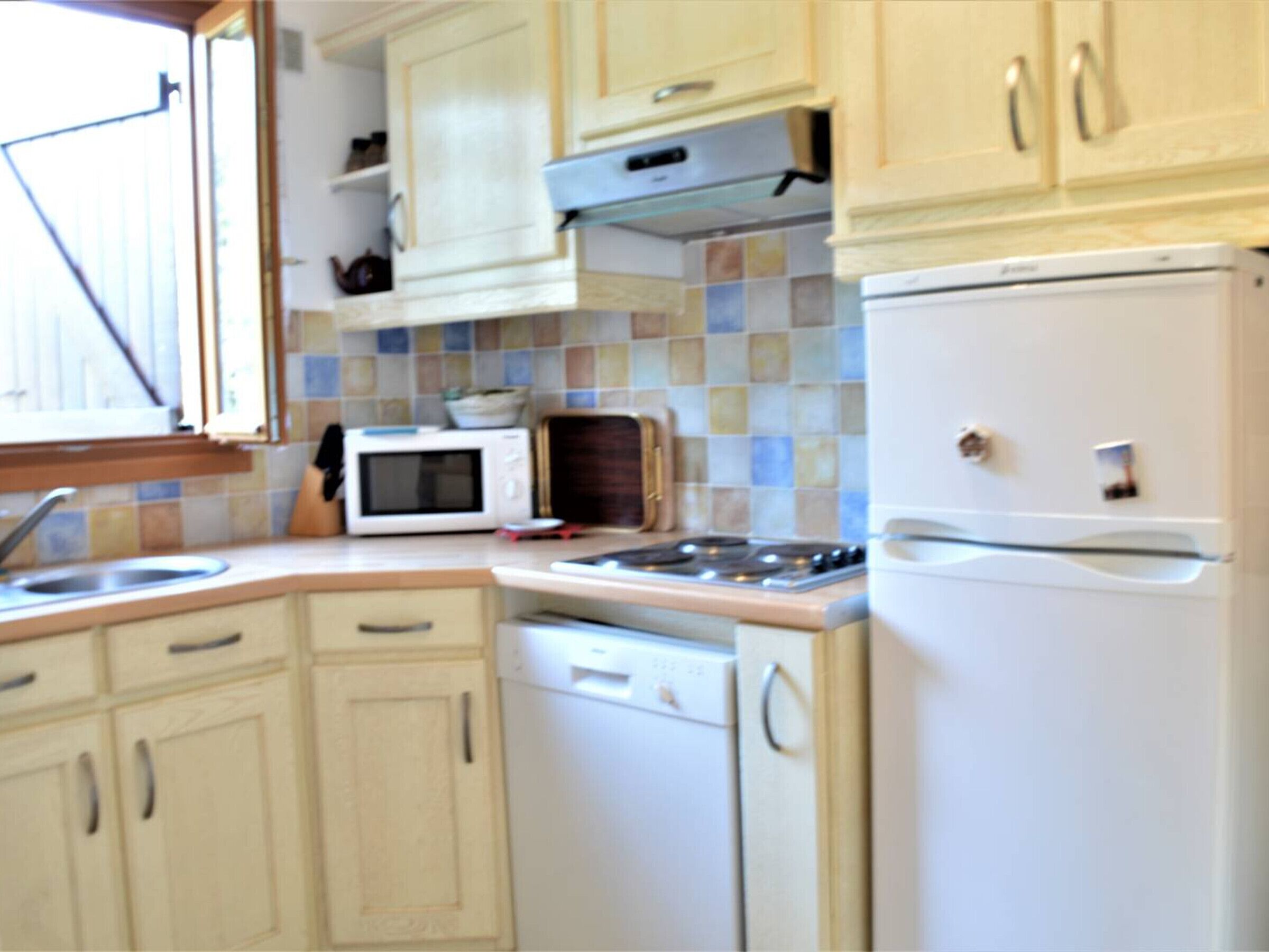 A compact kitchen with a microwave, stove, and refrigerator.