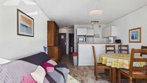 A compact living space with a sofa, dining table, and kitchenette. - 2-room apartment with terrace on beachfront for rent (Le Grau d'Agde)