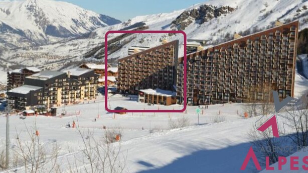 A hotel with multiple floors, a ski resort in the background, and a mountainous landscape. - Cozy Studio for 3, Ski-in/Ski-out, Balcony, South Exposure, Preyerand, Les Menuires (Les Menuires)