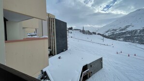 A snow-covered ski slope with a building adjacent to it. - Cozy Studio for 3, Ski-in/Ski-out, Balcony, South Exposure, Preyerand, Les Menuires (Les Menuires)