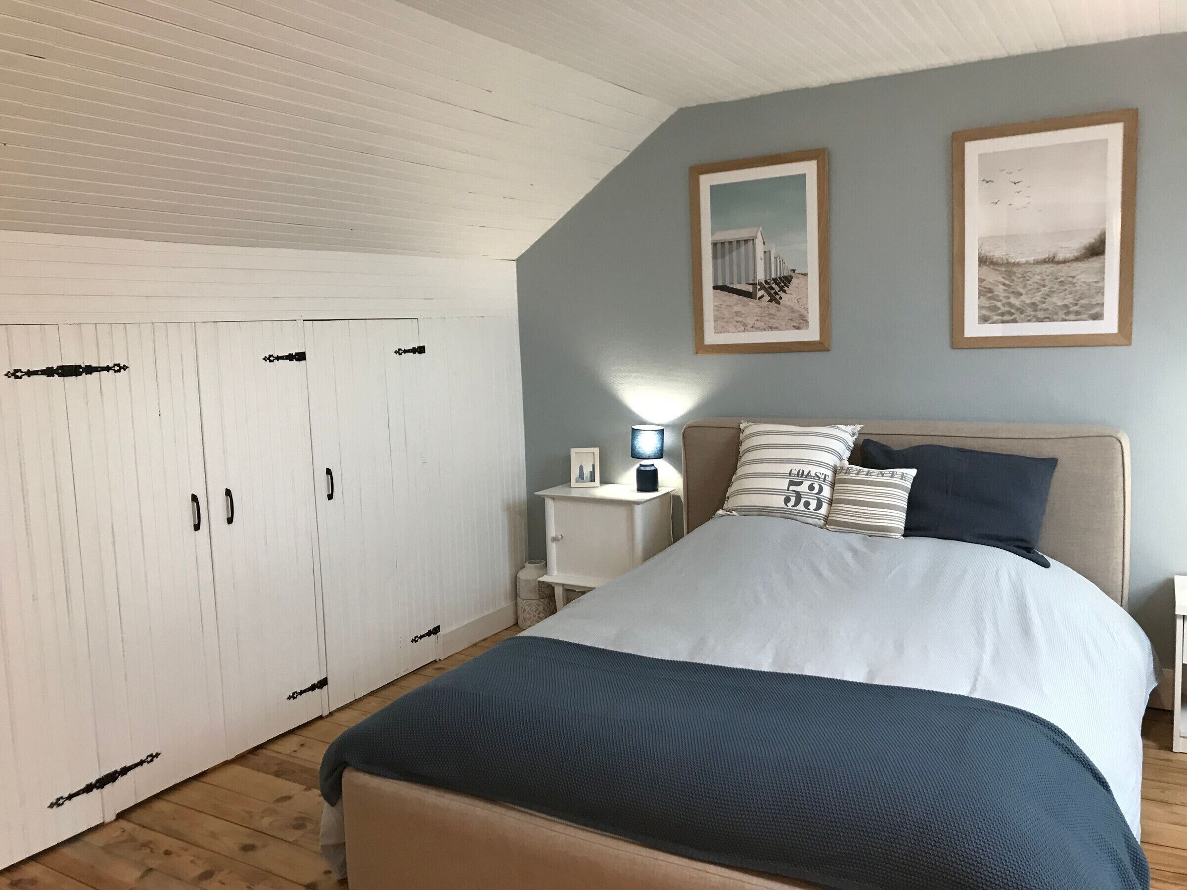 Ein Schlafzimmer mit Bett, Nachttisch und Kleiderschrank.