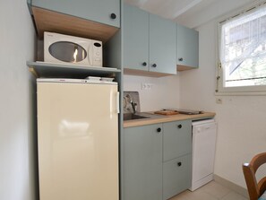 A compact kitchen with a refrigerator, microwave, and a small sink. - House with terrace, near beach and shops (La Palmyre)