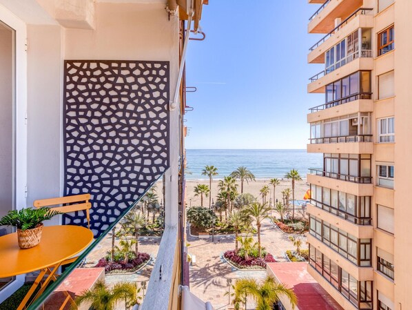A balcony with a view of the beach, a patterned wall, and a table with a plant. - Charming renovated apartment with balcony near the promenade in Estepona (Estepona)