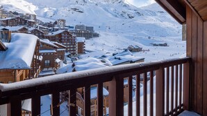 Un pueblo nevado en la montaña con edificios de madera y una pista de esquí.