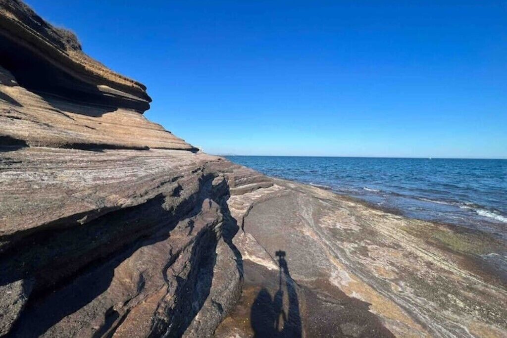 A coastal rock formation with a clear sky.