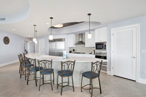 A modern kitchen with a central island, stainless steel appliances, and pendant lighting. - Escape to one of the Gulf Coast's premier destinations. Turquoise Place in Orange Beach, Alabama (Orange Beach)
