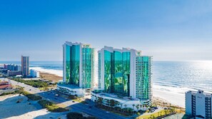 A beachfront hotel with multiple high-rise buildings, a parking area, and a road leading to the beach. - Escape to one of the Gulf Coast's premier destinations. Turquoise Place in Orange Beach, Alabama (Orange Beach)