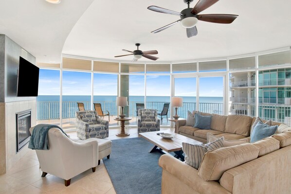 A spacious living room with a large window overlooking the ocean, a fireplace, and a ceiling fan. - Escape to one of the Gulf Coast's premier destinations. Turquoise Place in Orange Beach, Alabama (Orange Beach)