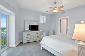 A bedroom with a bed, a dresser, a television, a ceiling fan, and a window with a view. - Escape to one of the Gulf Coast's premier destinations. Turquoise Place in Orange Beach, Alabama (Orange Beach)