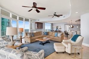 A spacious living area with a large sectional sofa, a coffee table, and a dining area in the background. - Escape to one of the Gulf Coast's premier destinations. Turquoise Place in Orange Beach, Alabama (Orange Beach)