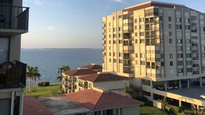 Un edificio alto con varios balcones que dan a una masa de agua.