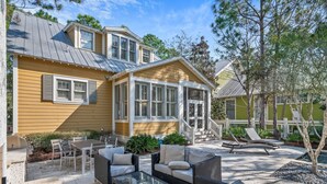 A house with a patio area featuring outdoor furniture and a grill. - WaterColor Escape |Bring the Whole Family—Pups Included! Sleeps 8 (Santa Rosa Beach)